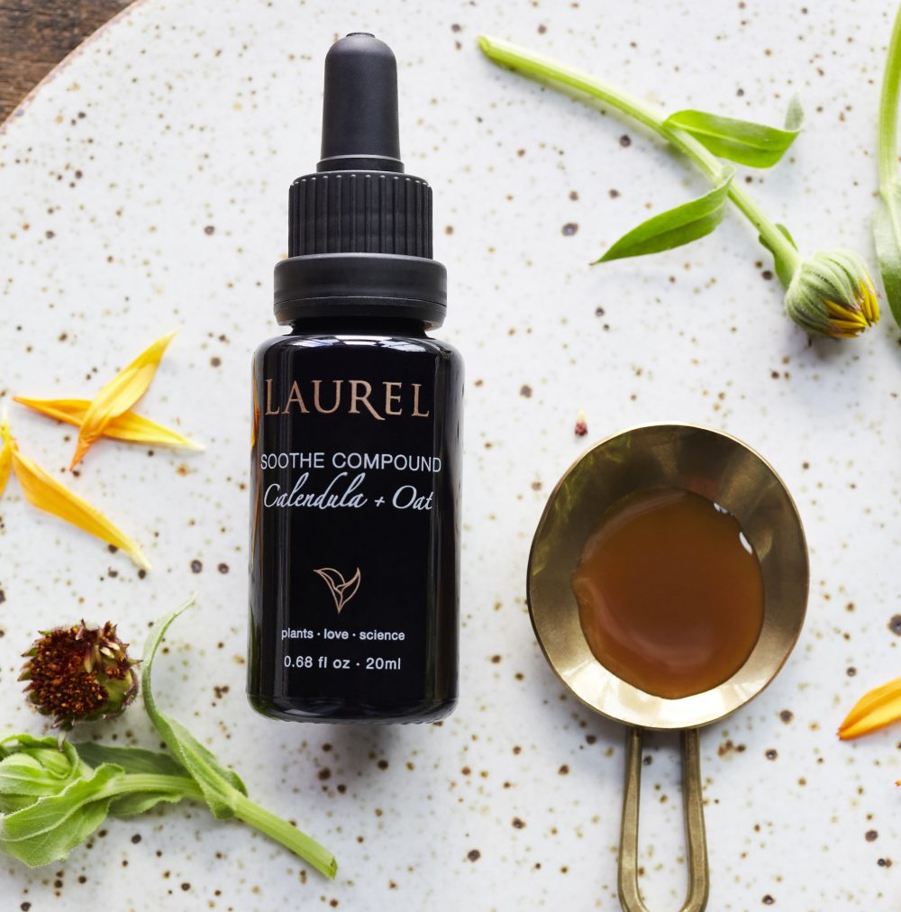 Soothe Compound resting on a marble tray surrounded by chamomile flowers and calendula petals.